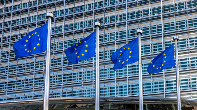Bruxelles, Belgique - 8 mars 2025: Drapeaux europ&eacute;ens, symboles de l'Union Europ&eacute;enne, flottant contre le b&acirc;timent Berlaymont, si&egrave;ge de la Commission Europ&eacute;enne