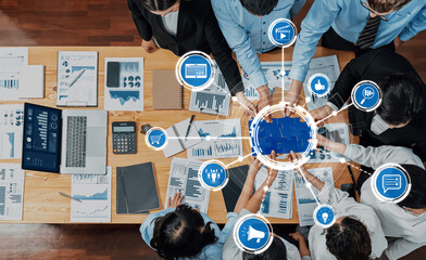 Aerial view of a diverse team collaborating over data analysis and charts in a modern office space....