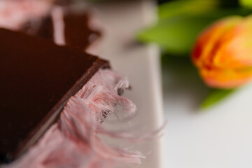 gourmet chocolate bar with pushmania filling (pink angel hair) inside a smooth chocolate shell. fresh tulips. concept of Turkish sweetness, artisanal confectionery, and luxurious dessert