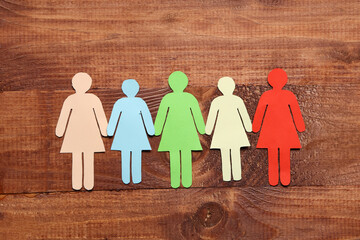 Paper female figures on wooden background