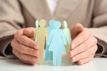 Woman with paper human figures at table, closeup
