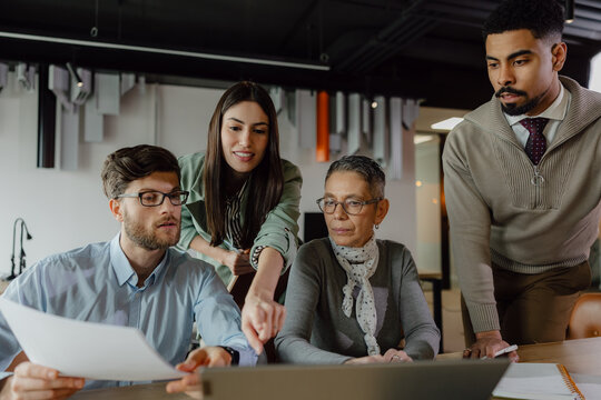 Collaborative Team Discussing Business Strategies in a Modern Office Setting - Powered by Adobe