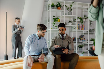 Colleagues Collaborating in a Modern Office Environment With Digital Devices