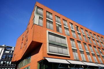 Klinkerfassade in leuchtendem Orange vor blauem Himmel im Sonnenschein am Hafenweg und Kreativkai...