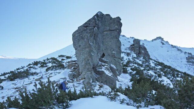 Girl with dog walking through snow among trees covered snow. Winter hike in mountains. Adventures in mountains.