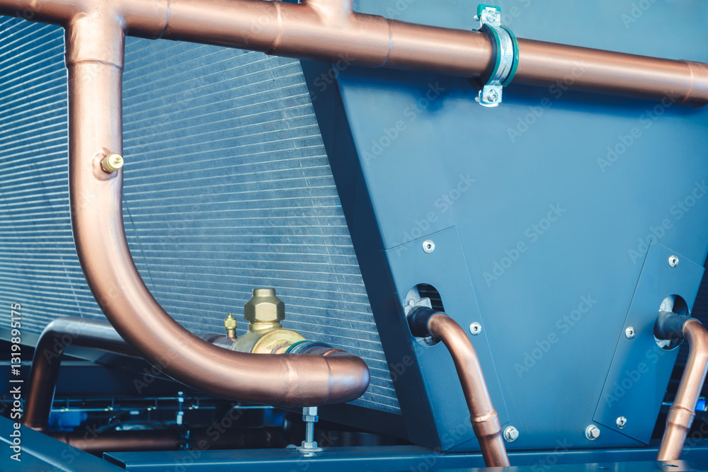 Poster pipe is made of copper and is curved. the pipe is attached to the wall. the pipe is curved in such a