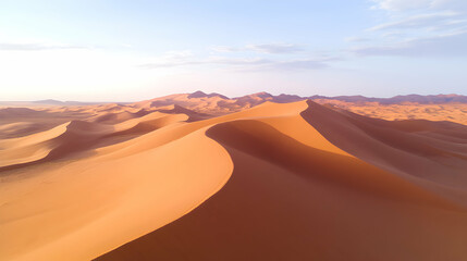 Naklejka premium A breathtaking view of sand dunes under a clear sky during sunset, showcasing the beauty of desert landscapes and the intricate patterns formed by wind on the golden sand.