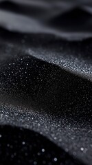 Abstract black sand dunes with shimmering specks create a mysterious and luxurious texture. Backgrounds, luxury design, and artistic compositions