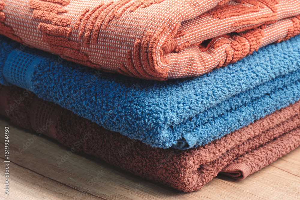 Fototapete three towels of different colors are stacked on top of each other. the blue towel is on the bottom, 