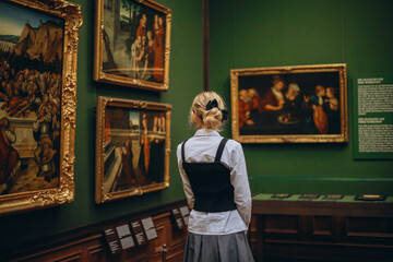 Dresden, Germany - December 25, 2024: Stylish Elegant Lady Visitor Tourist in Fashionable Outfit Admiring Masterpieces and Famous Paintings in Art Gallery Museum

