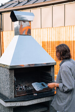 Traveler woman cooking on moderm grill near hotel. Woman doing barbecue
