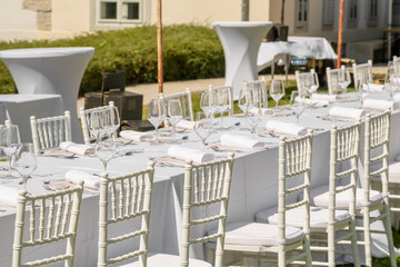 Served wedding table with plates, white chairs, napkins and wine glasses