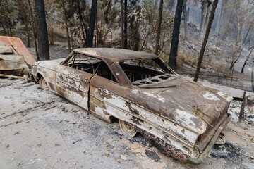Burnt-out car wreck sits in the aftermath of a wildfire in Santa Cruz, California, USA. The...