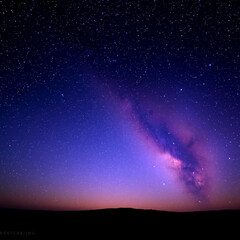 Obraz premium Majestic Sunset Over the Milky Way: A Cosmic Canvas of Stars and Colors