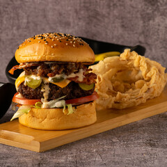 Brioche Cheeseburger with Pickles, Bacon, and Caramelized Onions with Onion Rings