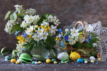 Easter still life with bouquets of spring flowers bird cherry, pansy, primrose, scilla in a vase...