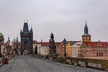 Charles Bridge with Old Town Bridge Tower stretching over Vltava River in Prague