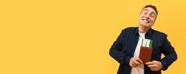 Overjoyed blonde handsome young guy tourist showing passport with flight tickets, boarding pass and grimacing, going vacation, isolated on yellow background, copy space