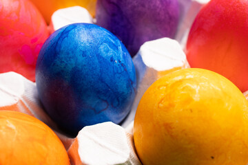 Multicolored Easter eggs lie in a white tray close-up