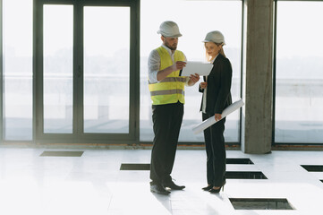 Construction Professionals Collaborate on Project Plans in Modern Office Space