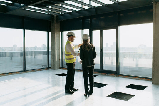 Construction Professionals Discussing Project Details in Modern Interior. architect or engineer and designer communicating at construction site