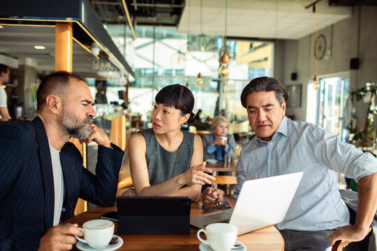 Diverse business team collaborating in modern cafe
