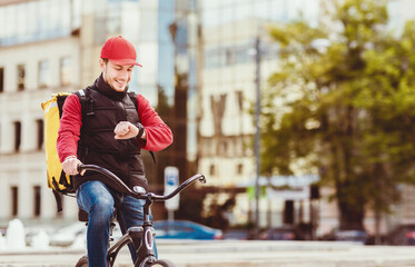 On-Time Food Delivery. Courier On Bike Checking Time On Wristwatch Delivering Meals From Cafes And...