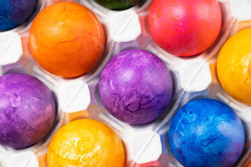 Multicolored Easter eggs lie in a white tray close-up