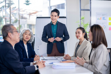 The man is giving a presentation and the group of people are listening