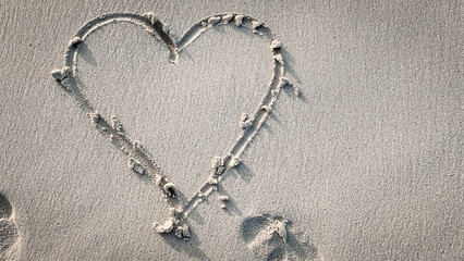 close-up of a heart drawn in the sand. beach vacation holiday background. wedding save the date...