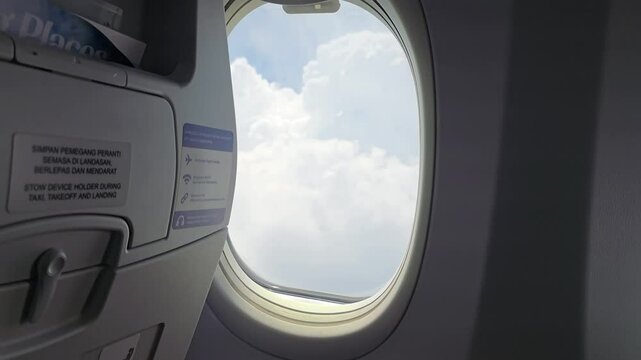Blurry view of airplane window during take off preparation in rainy weather.