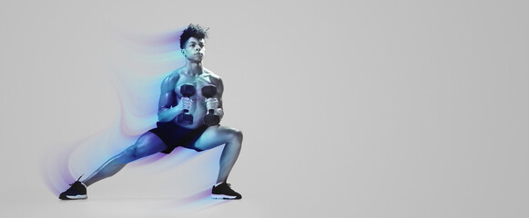 Athletic young man performing deep lunge while holding dumbbells, exercising on gray studio backdrop, full length. Strength and discipline, gym workout with weights concept