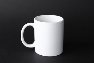 One blank white mug on black background. Mockup for design