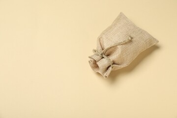 Burlap sack on beige background, top view. Space for text