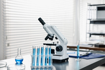 Chemical glassware and microscope on table in laboratory