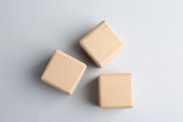 Blank wooden cubes on light grey background, flat lay