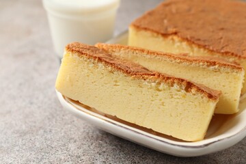 Tasty Japanese Castella sponge cake and milk on light table, closeup