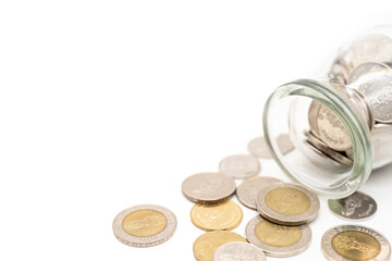Thai Baht Coins spilled out of jar glass isolated on white background, saving for future, Investment business concept. Copy Space for text.