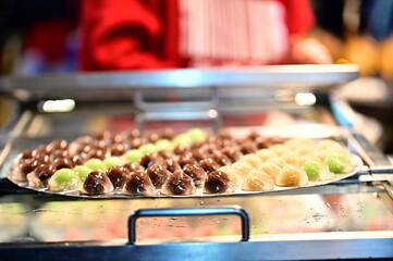 The night market’s golden lights shimmer against the smooth surface of liangyuan desserts. The peaceful yet lively atmosphere of the street food scene captures the charm of local Taiwanese culture.