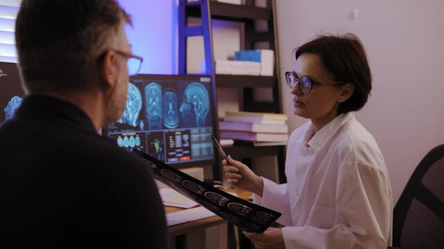 Medical hospital, A patient MRI scan is analyzed by doctors with patient to diagnose brain conditions and determine appropriate treatment.