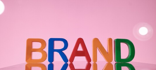 Colorful brand letters displayed on pink background creative concept studio environment eye-catching viewpoint