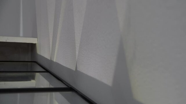 A pattern of water waves projected and reflected on a white wall by an illumination lighting device.