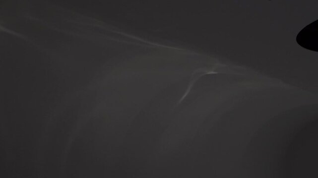A pattern of water waves projected and reflected on a white wall by an illumination lighting device.