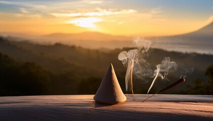 smoke incense cones on beautiful landscape background on sunset meditative scenery