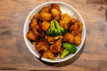 Overhead shot of a bowl filled with chicken and broccoli in a sweet and savory sauce, served over rice. A flavorful and satisfying meal.