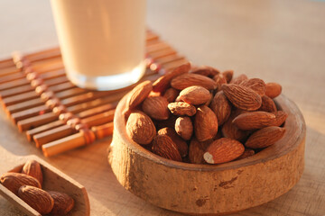 Almonds and milk on a wooden surface in warm sunlight