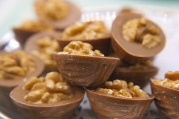 Delicious chocolate treats filled with crunchy nuts on plate