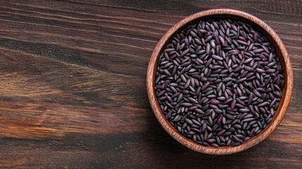 Antioxidant Extracts phytochemical. Bowl of black seeds on a wooden surface.