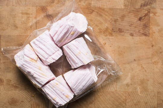 Overhead view of Nigerian Balewa candy in cellophane, top view of hausa alewa candy on a wood background, pulled hard sugar candy on a wood countertop