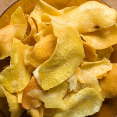 Overhead view of golden sweet potato chips on wood background, top view of crispy fried sweet...